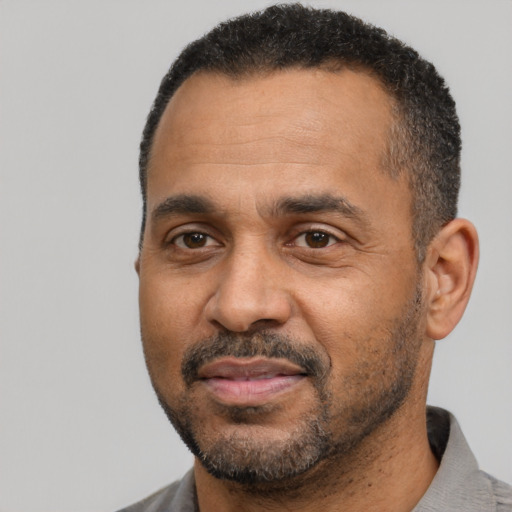 Joyful black adult male with short  black hair and brown eyes