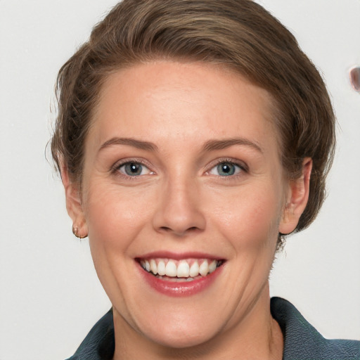 Joyful white young-adult female with short  brown hair and grey eyes