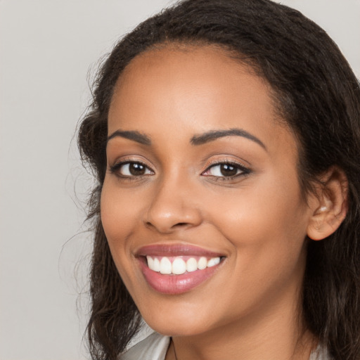 Joyful latino young-adult female with long  brown hair and brown eyes