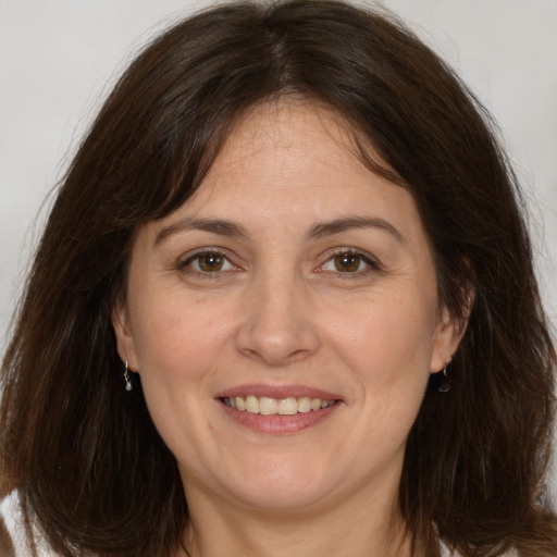 Joyful white adult female with long  brown hair and brown eyes