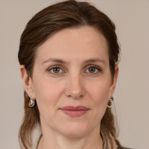 Joyful white adult female with long  brown hair and grey eyes