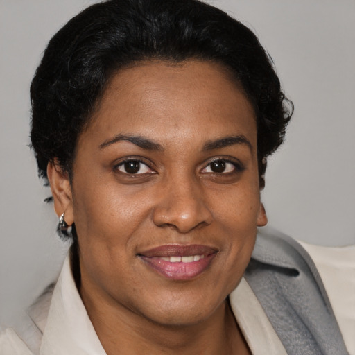 Joyful black adult female with short  brown hair and brown eyes