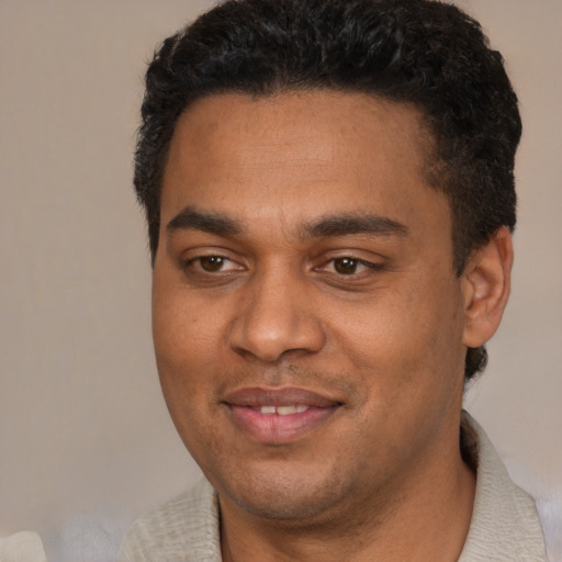 Joyful black young-adult male with short  black hair and brown eyes