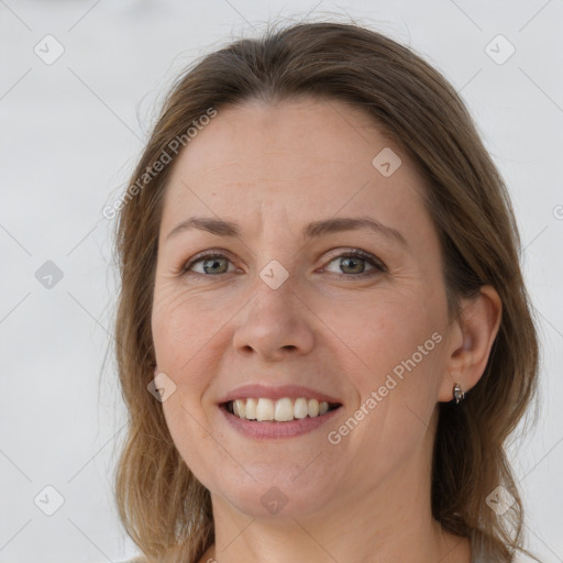 Joyful white adult female with medium  brown hair and grey eyes