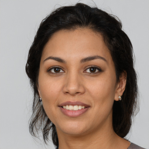 Joyful latino young-adult female with medium  brown hair and brown eyes