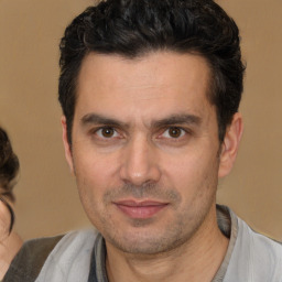 Joyful white adult male with short  black hair and brown eyes