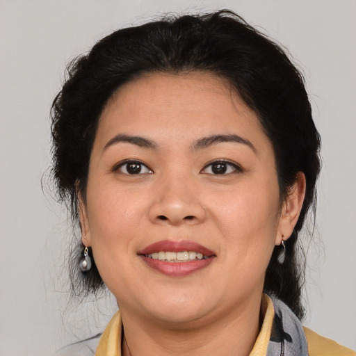 Joyful latino adult female with medium  brown hair and brown eyes