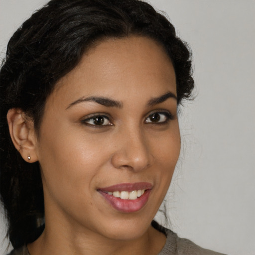 Joyful latino young-adult female with long  brown hair and brown eyes