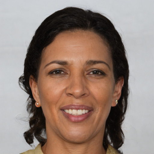 Joyful latino adult female with medium  brown hair and brown eyes