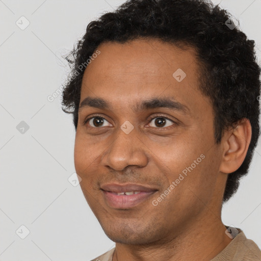 Joyful black young-adult male with short  brown hair and brown eyes