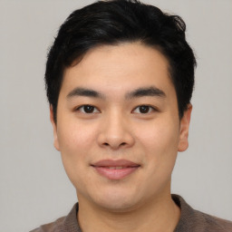 Joyful asian young-adult male with short  black hair and brown eyes