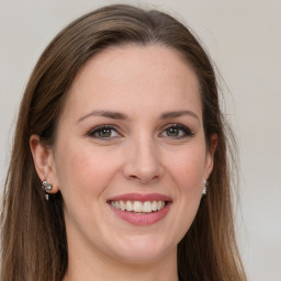 Joyful white young-adult female with long  brown hair and grey eyes