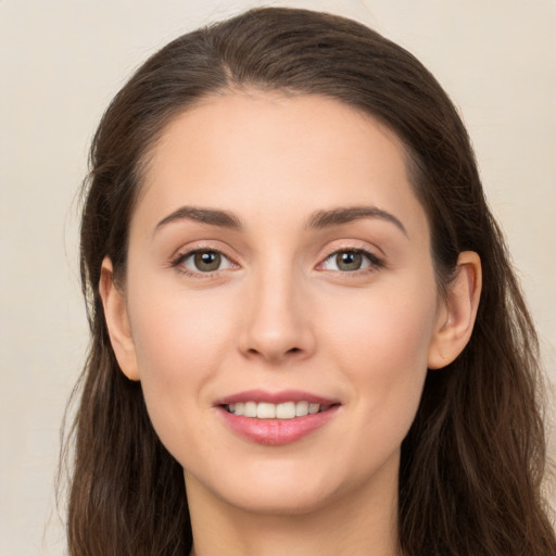 Joyful white young-adult female with long  brown hair and brown eyes