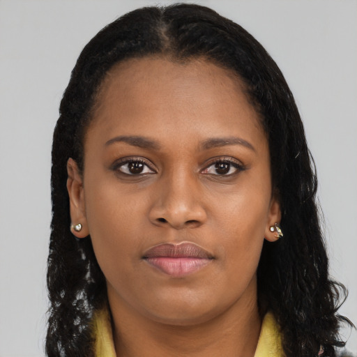 Joyful black young-adult female with long  brown hair and brown eyes
