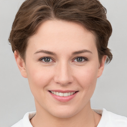 Joyful white young-adult female with short  brown hair and grey eyes