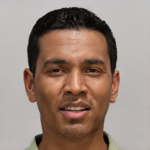 Joyful latino young-adult male with short  black hair and brown eyes