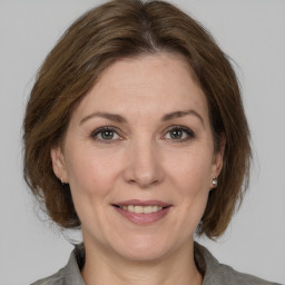 Joyful white adult female with medium  brown hair and grey eyes