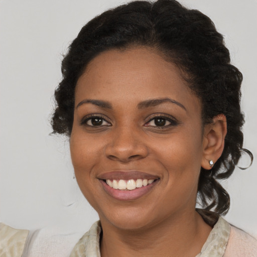 Joyful black young-adult female with medium  brown hair and brown eyes