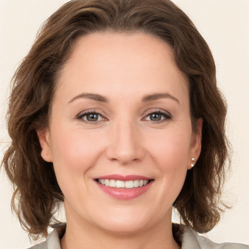 Joyful white young-adult female with medium  brown hair and green eyes