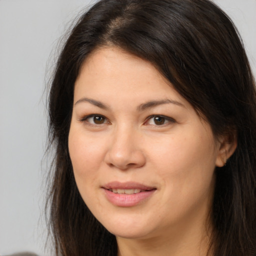 Joyful white young-adult female with long  brown hair and brown eyes