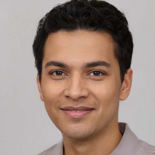 Joyful latino young-adult male with short  black hair and brown eyes