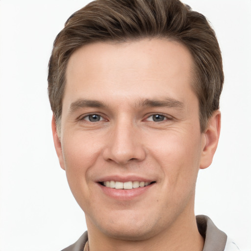 Joyful white young-adult male with short  brown hair and grey eyes