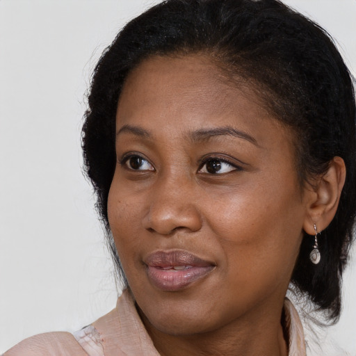 Joyful black adult female with long  brown hair and brown eyes
