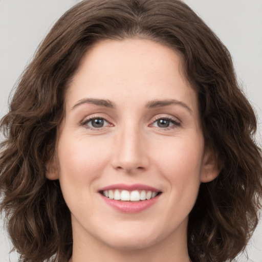 Joyful white young-adult female with long  brown hair and green eyes