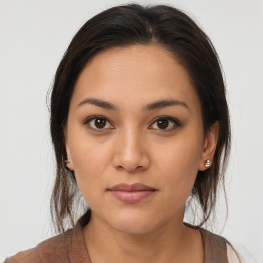 Joyful latino young-adult female with medium  brown hair and brown eyes