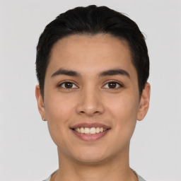 Joyful latino young-adult male with short  black hair and brown eyes