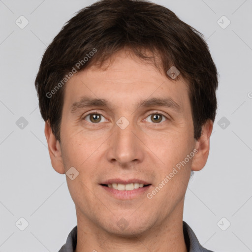 Joyful white young-adult male with short  brown hair and grey eyes