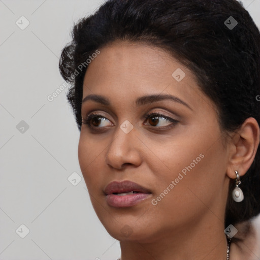 Joyful black young-adult female with long  brown hair and brown eyes