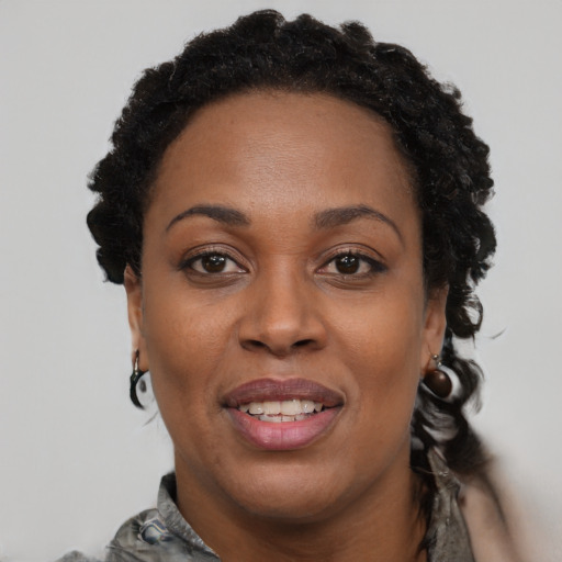 Joyful black adult female with short  brown hair and brown eyes