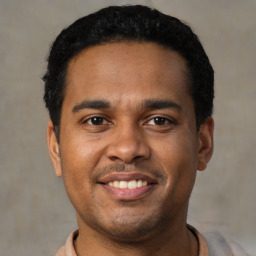 Joyful black young-adult male with short  black hair and brown eyes
