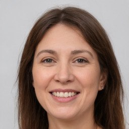 Joyful white adult female with long  brown hair and brown eyes