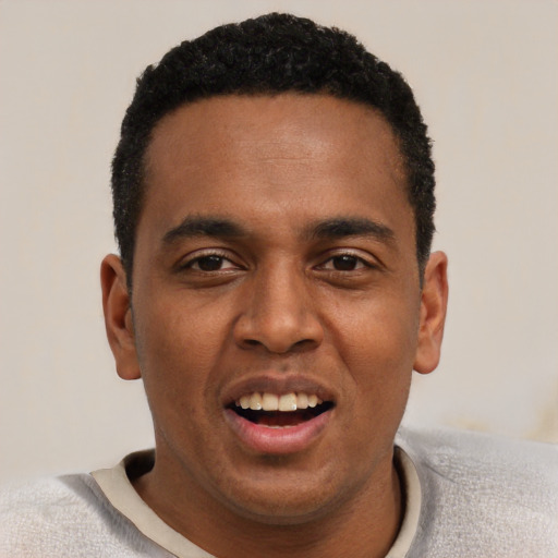 Joyful black young-adult male with short  black hair and brown eyes