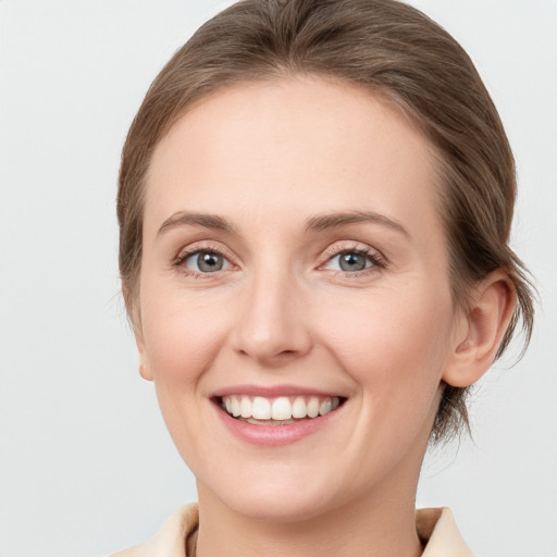 Joyful white young-adult female with medium  brown hair and grey eyes