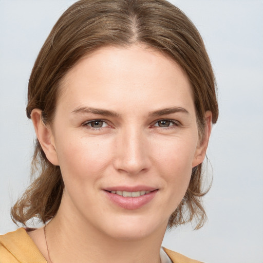 Joyful white young-adult female with medium  brown hair and grey eyes