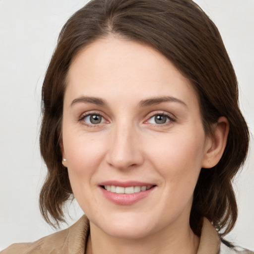 Joyful white young-adult female with medium  brown hair and grey eyes