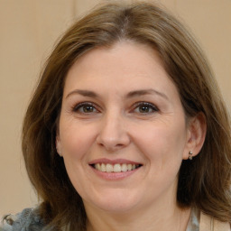 Joyful white adult female with long  brown hair and brown eyes