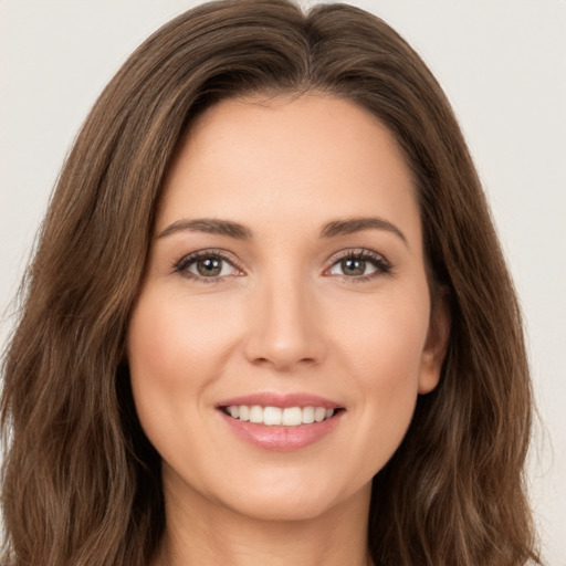 Joyful white young-adult female with long  brown hair and brown eyes