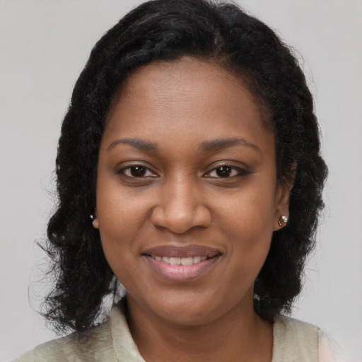 Joyful black young-adult female with long  brown hair and brown eyes
