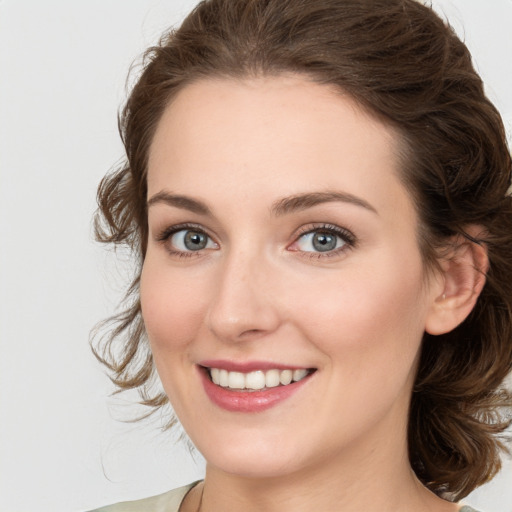 Joyful white young-adult female with medium  brown hair and green eyes