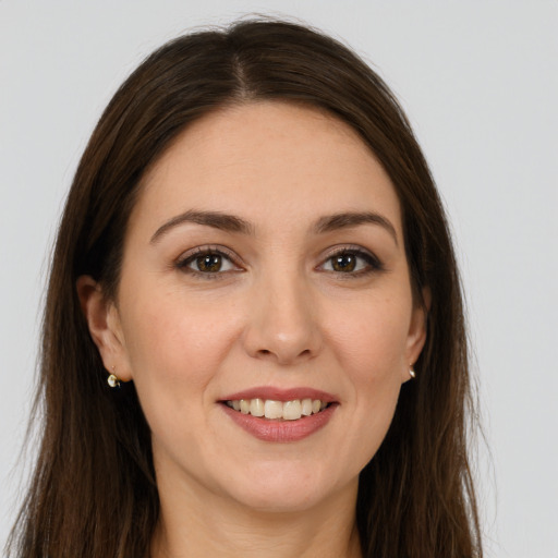 Joyful white young-adult female with long  brown hair and brown eyes