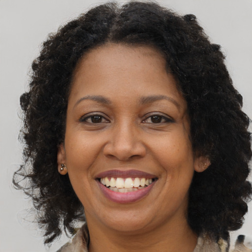 Joyful black adult female with medium  brown hair and brown eyes