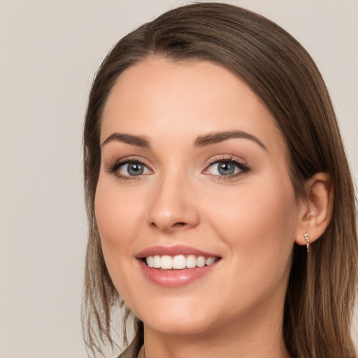 Joyful white young-adult female with long  brown hair and grey eyes