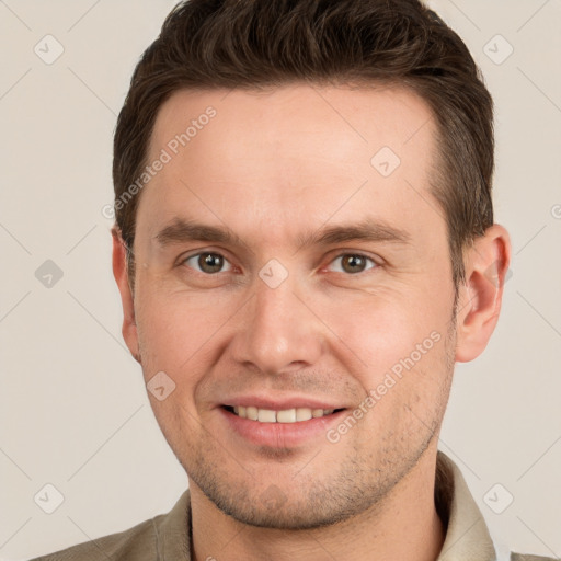 Joyful white young-adult male with short  brown hair and grey eyes