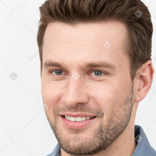 Joyful white young-adult male with short  brown hair and grey eyes