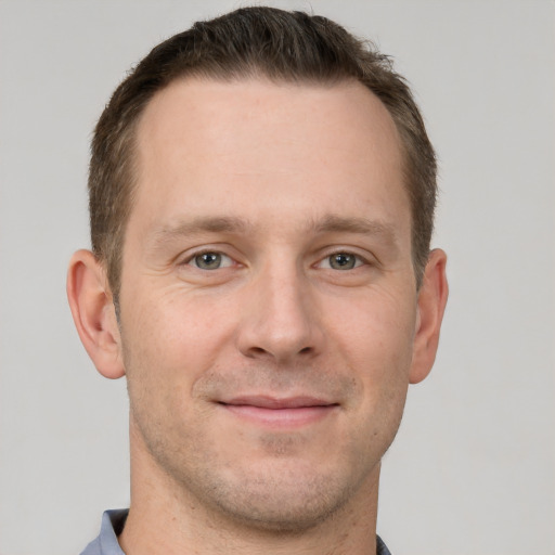 Joyful white adult male with short  brown hair and grey eyes