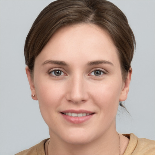 Joyful white young-adult female with short  brown hair and grey eyes